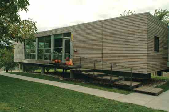 The home’s boxy design is softened by sustainably harvested Douglas fir cladding. Built on stilts, the home barely disturbs its infill site.